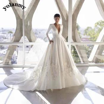 YOLANMY vestuvinė suknelė Satin ilgomis rankovėmis gilios V formos kaklo kišenės Sagų aplikacijos Iliuzija Iškirpta koplyčios traukinys Vestido De Casamento